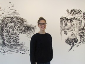 Assistant Curator Sonya Blazek stands next to large wall drawings by Toronto artist Kate Wilson in the lecture theatre at the Judith and Norman Alix Art Gallery in downtown Sarnia. The drawings are part of several new exhibitions opening Friday at the public art gallery. (PAUL MORDEN, The Observer)