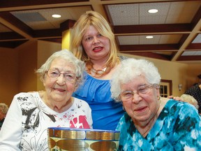 Audrey Howarth, left, and Elaine Hutt, right, residents and members of the craft club at the Waterford Kingston Retirement Residence, hold the Great Big Coffee Cup trophy with Mari Vepsalainen, the retirement residence’s lifestyle consultant, on Wednesday. (Julia McKay/The Whig-Standard)
