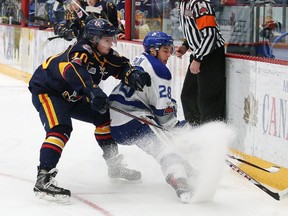 Drake Pilon, right, of the Sudbury Wolves, and Justin Murray, of the Barrie Colts, battle for the puck during OHL action at the Sudbury Community Arena in Sudbury, Ont. on Friday November 10, 2017. (John Lappa/Postmedia Network)