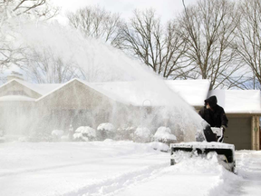 George Rennox of London uses a snowblower to empty a client's driveway of the white stuff on Friday February 2, 2018. Mike Hensen/The London Free Press/Postmedia Network