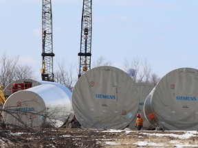 A worker walks between windmill components at a yard on the mainland near Millhaven, Ont. on Friday, Feb. 2, 2018.
Elliot Ferguson/The Whig-Standard/Postmedia Network