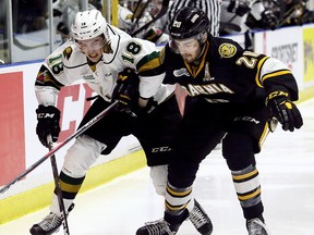 Sarnia Sting's Connor Schlichting (20) and London Knights' Liam Foudy (18) battle for the puck in the second period at Progressive Auto Sales Arena in Sarnia, Ont., on Saturday, Feb. 3, 2018. Mark Malone/Chatham Daily News/Postmedia Network