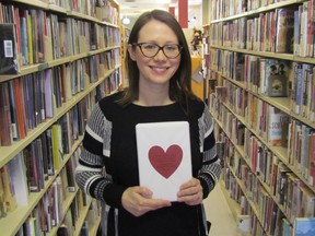 Adrianne Lebert, a reference librarian at the Sarnia Library, holds one of the titles from its shelves she has wrapped up for this year's Blind Date with a Book promotion. Patrons with a library card can take out a mystery book from the downtown library between Thursday and Feb. 15. (Paul Morden/Sarnia Observer)
