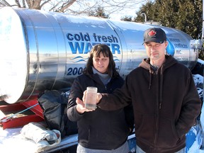 Paul and Jessica Brooks worry about where they will get their water in the future now that the Ministry of Environment and Climate Change has concluded the construction of the North Kent 1 Wind Farm project has not caused the water well to go bad on their home, north of Chatham, Ont. They are seen here on Monday February 5, 2018 in front of a water tank the wind developer is no longer required to provide due to the MOECC ruling. (Ellwood Shreve/Chatham Daily News/Postmedia Network)