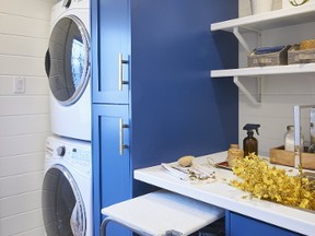 A stackable washer and dryer helps maximize available space; and going with white offers a bold contrast against the blue cabinetry.