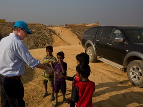UNICEF Deputy Executive Director Justin Forsyth, left, shares biscuits with Rohingya refugee children as he leaves Balukhali refugee camp 50 kilometres (32 miles) from, Cox's Bazar, Bangladesh Wednesday, Jan. 24, 2018. Forsyth is on a two day visit to Cox's Bazar to see, first-hand, the devastating humanitarian situation of the Rohingya refugees. AP Photo/Manish Swarup