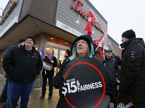 Protesters gather outside a Tim Hortons location in Peterborough, Ont. on Wednesday January 10, 2018 in response to some franchisees scaling back benefits in response to a provincial minimum wage increase. Clifford Skarstedt/The Examiner/Postmedia Network