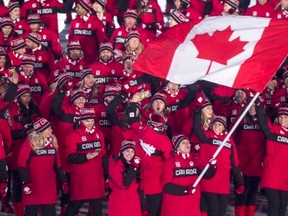 Ice dancers Tessa Virtue and Scott Moir lead the Canadian team into the Olympic Stadium during opening ceremonies for the Winter Olympics in South Korea.