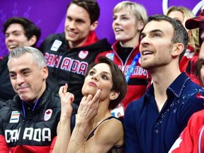 Canada’s Meagan Duhamel (2nd left) crosses her fingers as her partner Canada’s Eric Radford (2nd right) looks on. MLADEN ANTONOV / AFP/Getty Images