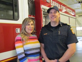 Noelle Frank, who is recovering after spilling scalding water down both of her legs last May, stands with Sarnia firefighter Mike Otis at the East Street Fire Hall in Sarnia. Frank spoke about her experience to raise awareness about the danger from scalding burns. (Paul Morden/Sarnia Observer/Postmedia Network)
