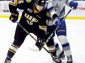 Sarnia Sting's Hugo Leufvenius (46) and Sudbury Wolves' Emmett Serensits (27) battle in front of the Wolves' net at Progressive Auto Sales Arena in Sarnia, Ont., on Sunday, Feb. 11, 2018. (Mark Malone/Postmedia Network)