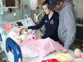 Faith Wright, two and a half, with her parents Maureen and Graham, is currently at the Children's Hospital of Eastern Ontario with complications from heart surgery. (Photo courtesy of Children's Hospital of Eastern Ontario)