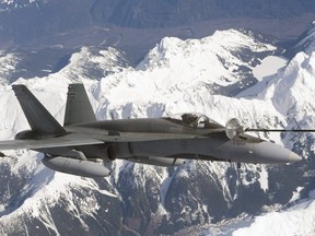 A CF-18 fuels up over the mountains.