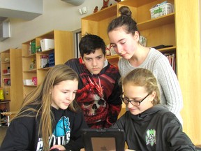 P. E. McGibbon Public School Grade 7 students, seated from left, Tamara Smith, 12, and Clara Veenendaal, 12, and standing from left, Ethan Duarte, 12, and Ella Derkzen, 12, use school-supplied iPads to create weekly video announcements at the Sarnia school. The Lambton Kent District School Board is asking parents and guardians of students in Grades 6 to 10 to take part in a survey on the future of a program providing iPads to students beginning in Grade 7. Paul Morden/Postmedia Network