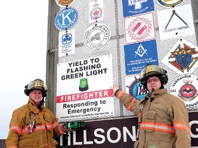 Tillsonburg firefighters Jason Bezaire and Dave Metselaar point out the Project Green Light sign on the Service Club signage coming into town on north Broadway. CHRIS ABBOTT/TILLSONBURG NEWS
