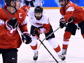 Canada's Eric O'Dell (C) skates between Switzerland's Raphael Diaz (L) and Switzerland's Denis Hollenstein in the men's preliminary round ice hockey match between Switzerland and Canada during the Pyeongchang 2018 Winter Olympic Games at the Kwandong Hockey Centre in Gangneung on February 15, 2018. / AFP PHOTO / Brendan SmialowskiBRENDAN SMIALOWSKI/AFP/Getty Images