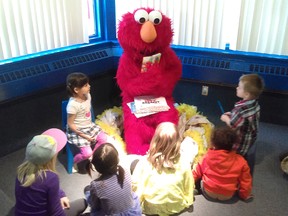Elmo from Sesame Street read to children at a Canadian Family and Corrections Network event at the Isabel Turner Library in 2015. Photo by Canadian Family and Corrections Network
