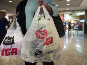 In this file photo, a woman leaves a grocery store in Montreal carrying plastic bags on Friday, May 15, 2015. Ryan Remiorz / THE CANADIAN PRESS