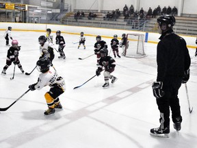 Coach Chad Verberne (right) of the Mitchell Chips 3A/3B Initiation (tyke) program, watches one of two games of hockey being played at cross-ice/half-ice at the Mitchell & District Arena recently. Rather than use boards to separate the games, volunteer coaches keep an eye on any loose pucks. ANDY BADER/MITCHELL ADVOCATE