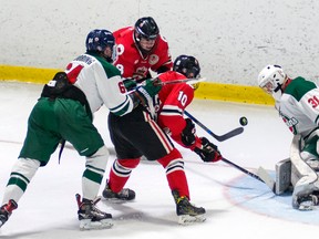 Jon Sanderson of the Sarnia Legionnaires (No. 10 in red) and linemate Greg Hay (No. 8) swat at a loose puck in front of the St. Marys Lincolns net during a Jr. 'B' hockey game Thursday. The Legionnaires are back in action Saturday night at the Brock Street rink, when they host the visiting Leamington Flyers. (Handout/The Observer)