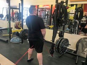 Farr Ramsahoye/Visionary Fitness
Jan Murphy performs a squat stance deadlift with a resistance band for accommodating force under the guidance of his trainer, Farr Ramsahoye of Visionary Fitness, during training at 247 Fitness on Gardiners Road this week.
