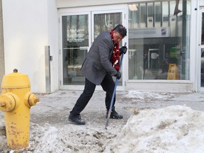 Ward 2 Coun. Michael Vagnini removes a section of a snowbank for pedestrians on Cedar Street in downtown Sudbury, Ont. on Saturday February 17, 2018. John Lappa/Sudbury Star/Postmedia Network