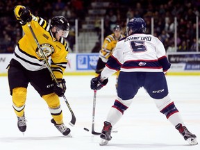 Sarnia Sting's Hugo Leufvenius, left, tries to skate around Saginaw Spirit's Marcus Crawford during the first period at Progressive Auto Sales Arena in Sarnia, Ont., on Monday, Feb. 19, 2018. (Mark Malone/Postmedia Network)