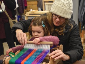 Leah Hanna, age 4.5, tries her hand at weaving with a sample weaver, and help from her mom Jeanette, during one of the many Family Day activities at the Tett Centre for Creativity and Learning in Kingston, Ont. on Monday February 19, 2018.