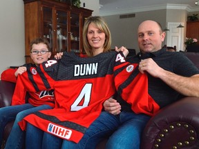 The Dunns -- from left, Nathan, Coralee, and Jeremy -- hold James Dunn's hockey jersey, similar to the one he'll wear this March for the 2018 South Korea Paralympic Games. Dunn, 17, is only a few years removed from cancer treatment that took his leg and almost, his life. (Louis Pin // Times-Journal)