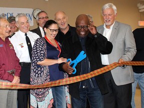 A good laugh was enjoyed by all when it was realized this large pair of plastic scissors wasn't going to allow the official ribbon cutting for the Chatham Hope Haven to proceed during a grand opening event held for the men's shelter in Chatham on Monday. (Ellwood Shreve/Postmedia Network)