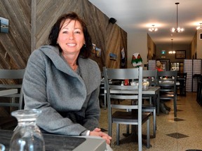 Kathleen Anderson sits in Tia’s Place in Strathroy, her latest award-winning heritage restoration project. Anderson handles everything from the overall vision to the little details — from the unique lighting, to the bar in the back, to the restored, original flooring found at the front of the store. (LOUIS PIN, Postmedia News)