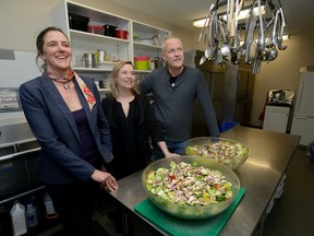 Silke Nebel, left, Tosha Densky, and Paul Van der Werf of the Middlesex-London Food Policy Council tour the kitchen at Ark Aid Mission Tuesday. Ingredients for the salads were donated by London restaurants. (MORRIS LAMONT, The London Free Press)