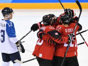 Canadian players celebrate Maxim Noreau’s goal against Finland on Feb. 21.