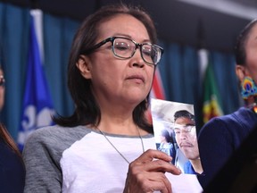 Debbie Baptiste, mother of Colten Boushie, holds a photo of her son during a press conference on Parliament Hill in Ottawa on Wednesday, Feb. 14, 2018. (THE CANADIAN PRESS/Justin Tang)