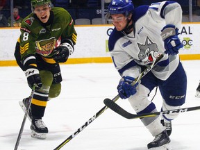 Blake McConville (11), of the Sudbury Wolves, attempts a back-hand shot as North Bay Battalion forward Matthew Struthers (18) defends during the first period of OHL action at Memorial Gardens, Wednesday. Sudbury scored twice in the first but the Troops rallied and won 3-2 in overtime. Dave Dale / The Nuggget