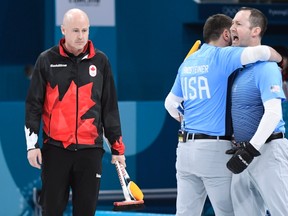 Canada skip Kevin Koe looks on as members of Team USA celebrate winning the match during men's semifinal curling action against the USA at the 2018 Winter Olympics in Gangneung, South Korea, Thursday. THE CANADIAN PRESS/Nathan Denette