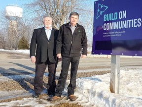 Dutton Dunwich councillor Dan McKillop, left, and Mayor Cameron McWilliam stand beside a Wallacetown water tower project sign. The tower, visible in the background, is undergoing a $448,880 rechlorination system upgrade covered through provincial grants and municipal funds. (Vicki Gough // Special to Postmedia News)