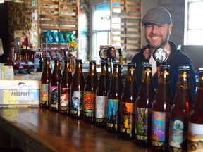 Scott Hannah, event coordinator with Railway City Brewing Co., stands behind the twelve custom beers designed for this year's Railway City Arts Crawl. Now in its fifth year, the crawl highlights local art and business in the downtown core of St. Thomas with a few outliers -- like Railway City Brewing and the STEAM Centre on Wellington Street. (Louis Pin/Times-Journal)