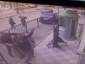 In this screenshot, three Egyptian policemen attempt to catch a five-year-old child before he falls from a third-floor apartment balcony in the southern city of Assiut on Feb 22, 2018.