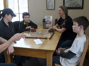 Dan Bueckert, left, of Huron Park, invented Factions: The Board Game back in the 1990s. After some changes through the years, Bueckert and his daughter Vanessa are now marketing the game and holding game days at the Exeter Library. Pictured above from left are Bueckert, Jenni and Jack Boles, Vanessa Bueckert and Tom Boles during a recent match at the library.