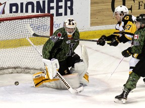 Kingston Frontenacs goalie Jeremy Helvig makes a save as Hamilton Bulldogs' Robert Thomas watches the shot go wide while Frontenacs captain Ted Nichol backchecks during Ontario Hockey League action at the Rogers K-Rock Centre in Kingston on Friday night. (Ian MacAlpine/The Whig-Standard)