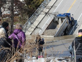 Onlookers gather at the collapsed Imperial Road bridge in Port Bruce on Sunday. The structure gave out while a fully-loaded dump truck was driving across it Friday. (DALE CARRUTHERS / THE LONDON FREE PRESS)