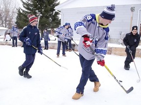 Sudbury Wolves forward Macauley Carson plays hockey on Sunday with youngsters at Jodi O'Bonsawin's backyard rink, this year's winner of the Home Depot Backyard Rink contest in Greater Sudbury. Several members of the Sudbury Wolves paid a visit to the winner of this year's rink contest and participated in a game of shinny with the winners. (Gino Donato/Sudbury Star)