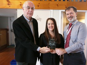 Meghan Balogh/The Whig-Standard
Dan Corbett, left, board chair for Family and Children's Services of Frontenac, Lennox and Addington, and Steve Woodman, family services executive director, right, presented the 2018 Family Advocacy Award to One Roof, a youth services hub in downtown Kingston. One Roof co-ordinator Ashley O’Brien, centre, accepted the award on Tuesday.