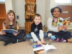 Grade 3 French immersion students Hannah Brooks, left, Emmanuel Fillion and Adonia Adeyemi look forward to reading the new books that will be added to the library collection at Levack Public School in the spring. Supplied photo