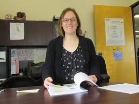 Shauna Carr, executive director of the Sarnia Lambton Workforce Development Board, looks through a copy of the agency's recent Local Labour Market Plan. It's produced annually to tell the story of the labour market in Sarnia-Lambton. (Paul Morden/Sarnia Observer/Postmedia Network)