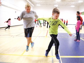 Lace Marie Brogden, dean of the Faculty of Education at Laurentian University, and Evan Burton, 9, perform crossovers during the launch of Active Sudbury's physical literacy initiative at Churchill Public School in Sudbury on Wednesday. To learn more, visit www.activesudbury.ca. John Lappa/Sudbury Star/Postmedia Network