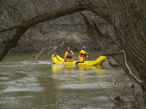 Firefighters use their rescue boats to search the south branch of the Thames River near Vauxhall Park in London, Ont. (MIKE HENSEN, The London Free Press)