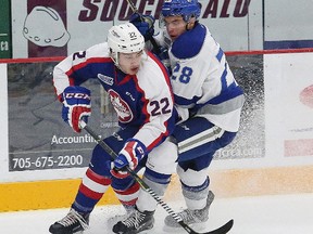 Drake Pilon, right, of the Sudbury Wolves, and Thomas Steveneson, of the Windsor Spitfires, battle for the puck during OHL action at the Sudbury Community Arena in Sudbury, Ont. on Friday October 27, 2017. John Lappa/Sudbury Star/Postmedia Network