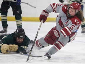 Callum Roque of the St,. Charles Cardinals get hauled down by Mason Blinn of the Confederation Chargers during the boys high school hockey division A championship game in Sudbury, Ont. on Thursday March 1, 2018. St. Charles defeated Confederation 5-0 to take the city championship.Gino Donato/Sudbury Star/Postmedia Network